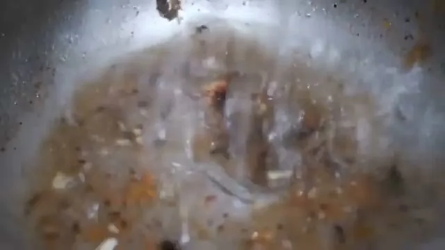 Camera view down a pipe showing orange rust scale and debris on the inner wall